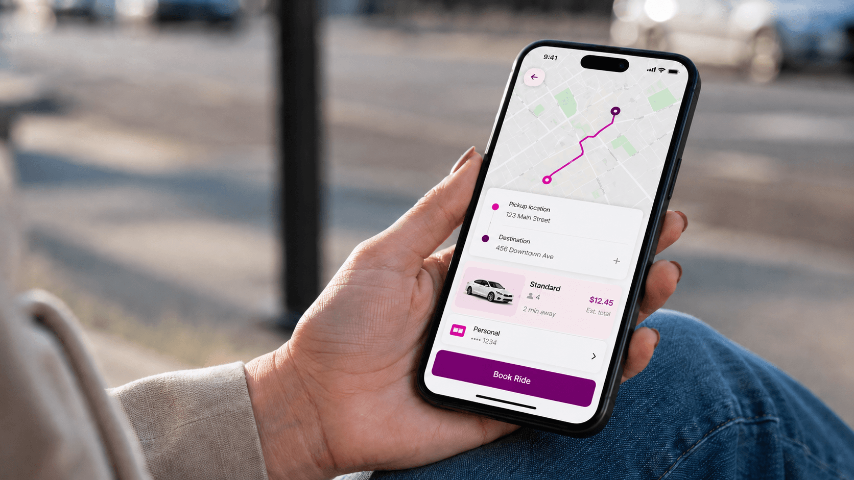 Hand holding a phone to book a Woom ride